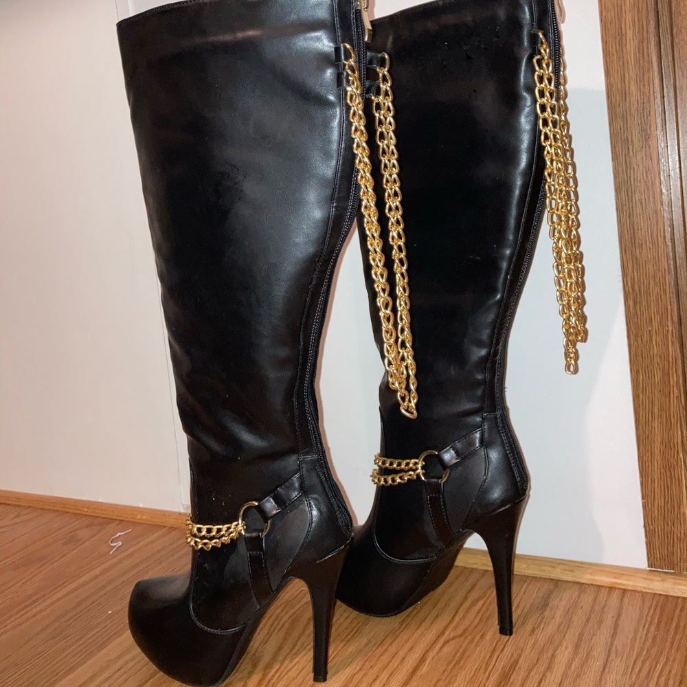 Black knee high boots with gold chain accent